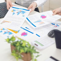 それっぽく出来上がった資料を使ってプレゼンする会議室の様子の写真