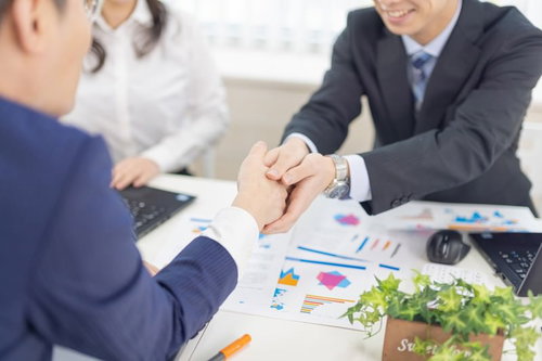 両手でクライアントの手を握りしめる担当者