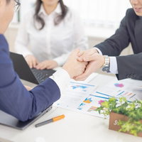 みごと商談成立、握手するビジネスマン、成功するオフィス風景の写真