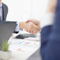 ビジネスシーンでの握手と企画成約のミーティング風景の写真