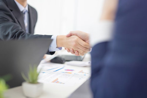 ビジネスシーンでの握手と企画成約のミーティング風景