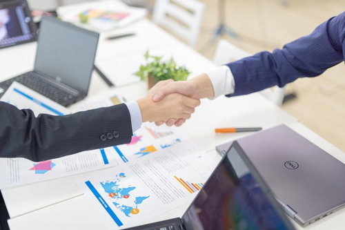 会議室での契約成立、握手を交わすビジネスマン