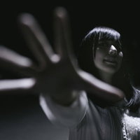 この束縛からは逃げられない...暗闇に手を伸ばす女性の写真