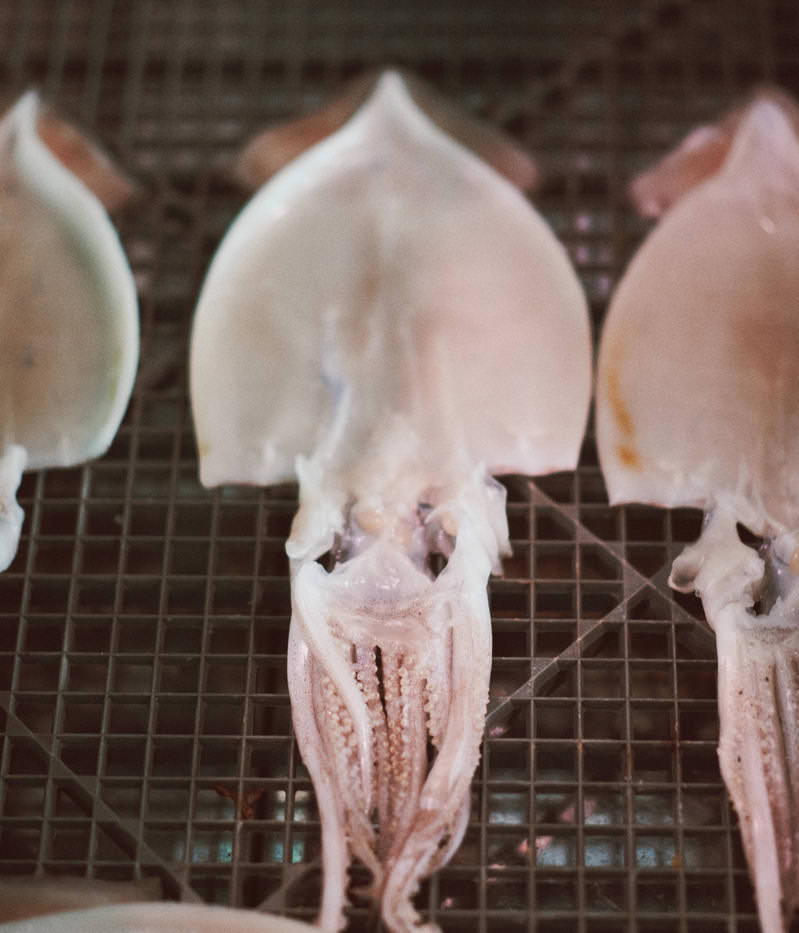 小名浜港の魚市場に並べられた白いスルメの干物とピンク色のゲソ