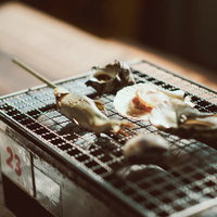 いわき市の魚市場で網焼きするはまぐりとサザエの写真