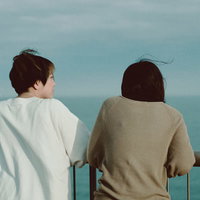 展望台から海を眺める女性二人の後ろ姿の写真