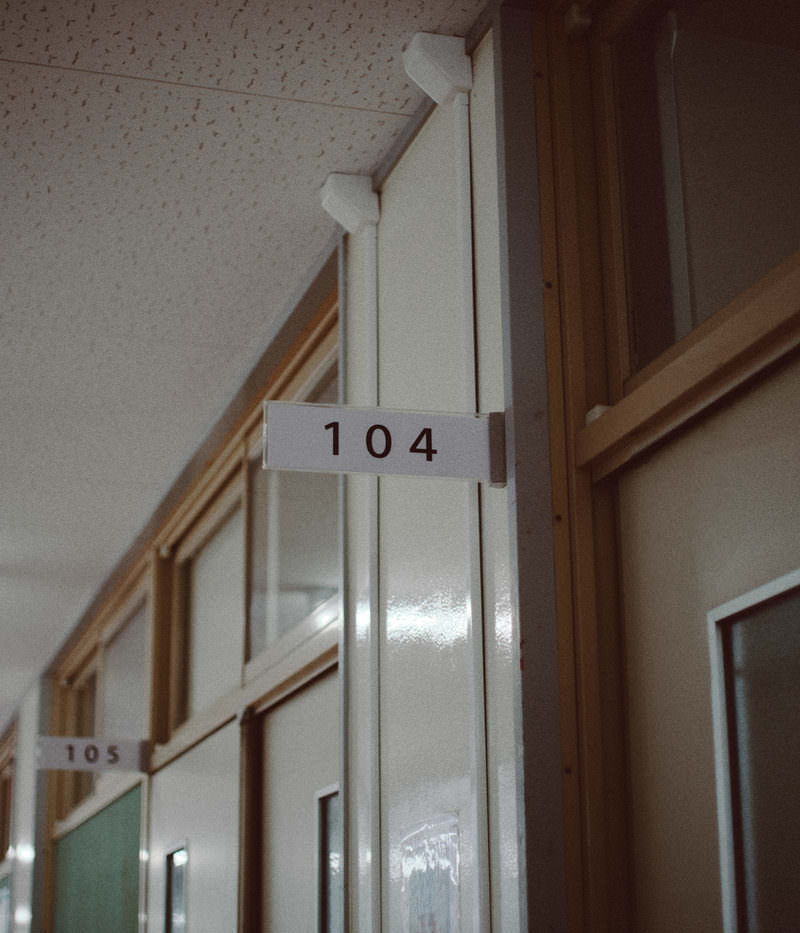 白いドアに「104」の番号プレートが貼られた教室の入り口