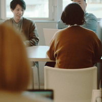 コワーキングスペースでミーティングを開く男性を含むメンバーの写真