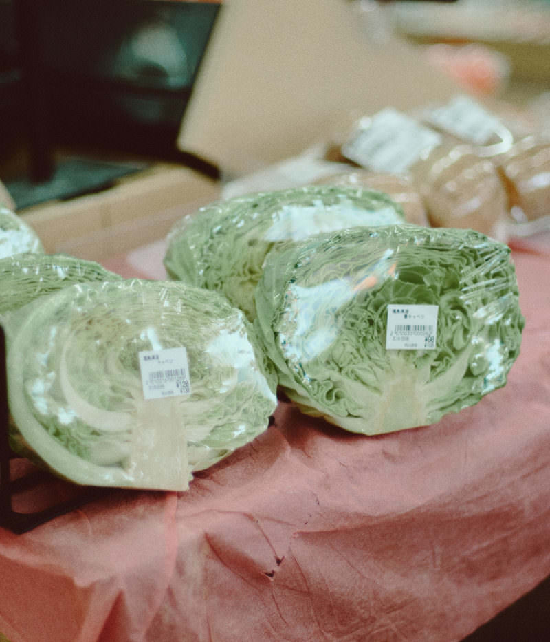 小高ストアの販売台に並んだ1/2カットキャベツ。緑色の葉が層状に広がっている