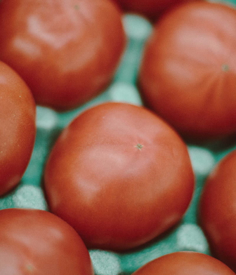 小高ストアで販売されている赤いトマトが緑色の箱に詰められている