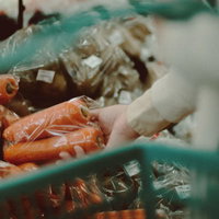 小高ストアの野菜コーナーで人参を手に取るの写真