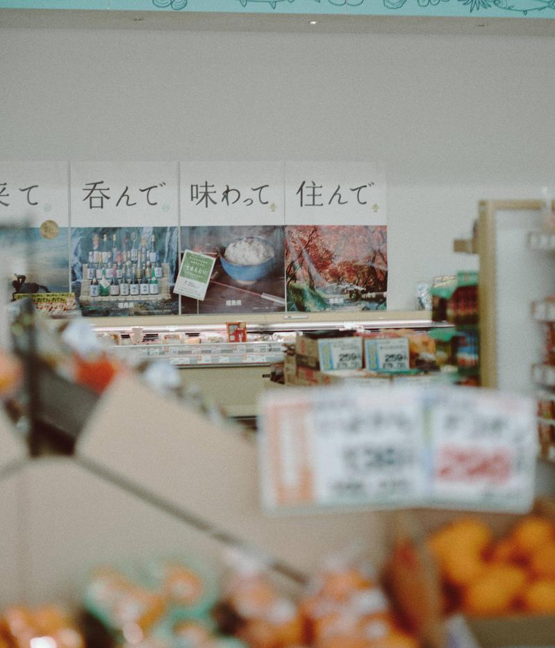 福島県南相馬市の小高ストア店内。商品棚に並ぶ食品とポスター