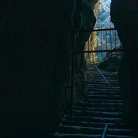 備中鐘乳穴の入り口から差し込む光と階段、洞窟内の自然光景の写真