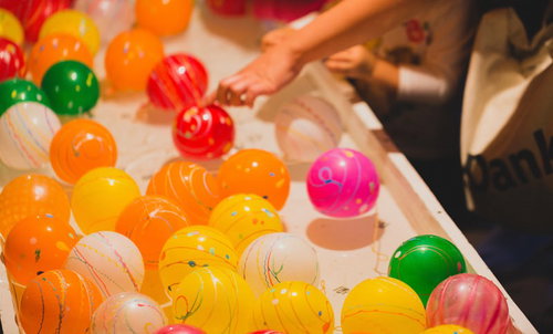 夏祭りの出店で並ぶカラフルな水風船すくい