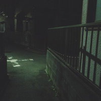 深夜の住宅街を照らす街灯の細い路地と静寂の夜景の写真