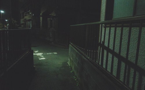 深夜の住宅街を照らす街灯の細い路地と静寂の夜景