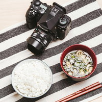 一眼レフカメラと和食の朝食を並べた日常風景の写真