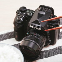 PENTAXの一眼レフカメラと和食の朝食の写真
