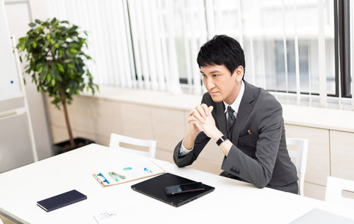 約束の時間になってもクライアントが来ない状況で悩む男性