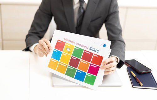 SDGs持続可能な開発目標の資料を持つビジネスマン