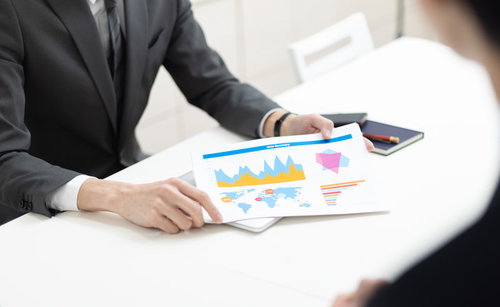 ビジネス会議でグラフ資料を見せてくる説明の手元