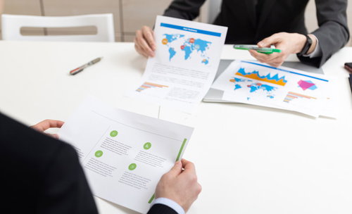 紙に印刷した資料を手に持ちながら会議がはじまる