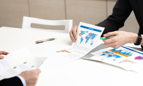 複数のグラフと資料を使って説明する会議の様子