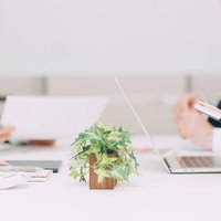 スーツ姿でテーブルを囲んで進める会議中の打ち合わせの写真