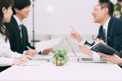 会話が弾む会議室での打ち合わせ：ビジネスパーソンの商談風景