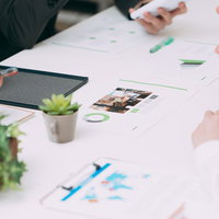 資料を見ながら打ち合わせをすすめるビジネスシーンの写真