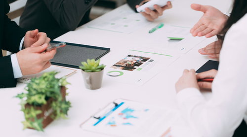 資料を見ながら打ち合わせをすすめるビジネスシーン