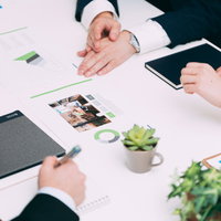 会議室で資料を確認しながら打ち合わせするチームメンバーの写真