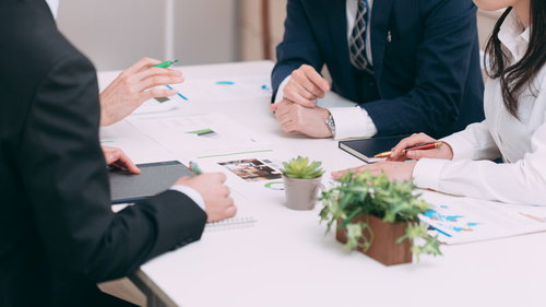 セールスチームが会議室で資料を広げて打ち合わせ