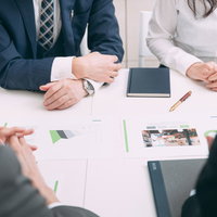 4人で会議する様子、会議室での打ち合わせシーンの写真