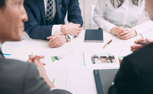 4人で会議する様子、会議室での打ち合わせシーン