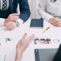 課題について資料を前に真剣に議論するビジネスパーソンの写真