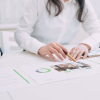 資料を使って適時説明する女性営業スタッフのビジネス打ち合わせの写真