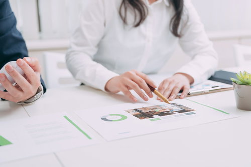 資料を使って適時説明する女性営業スタッフのビジネス打ち合わせ