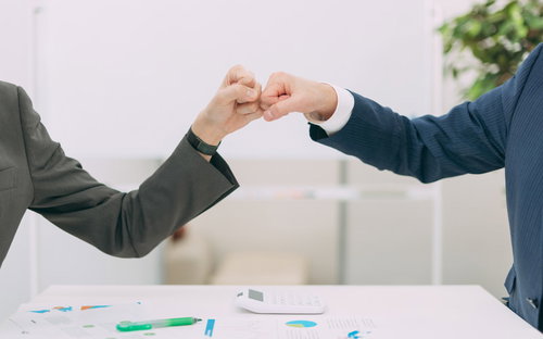 スーツの男性がフィストバンプする会社員の感染対策