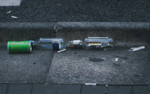 路上呑み後に散乱したゴミと空き瓶、吸い殻による路面汚染