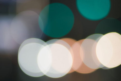 緑色とオレンジの玉ボケが重なるキラキラした光