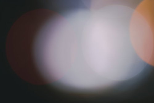 暖色系の光が大きく滲んだボケ味と玉ボケが美しい背景