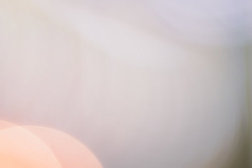 一面に滲むグレー色のボケ味と玉ボケ、柔らかく淡い光の背景