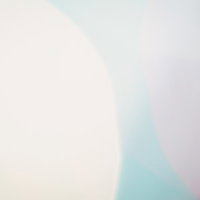 ピンク・水色・白の三色が重なる大きなボケの写真