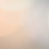 オレンジ色の淡い光と玉ボケ｜柔らかくぼやけた抽象的な光の背景の写真