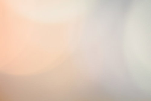 オレンジ色の淡い光と玉ボケ｜柔らかくぼやけた抽象的な光の背景