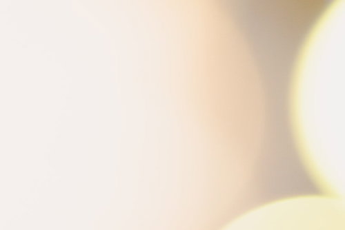 黄色とオレンジ色の大きな玉ボケ、温かみのある光の背景