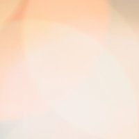 一面に広がるオレンジ色のボケ味と光のグラデーションの写真
