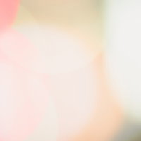 中心が白くにじむネオンのぼけた光と暖色グラデーションの写真