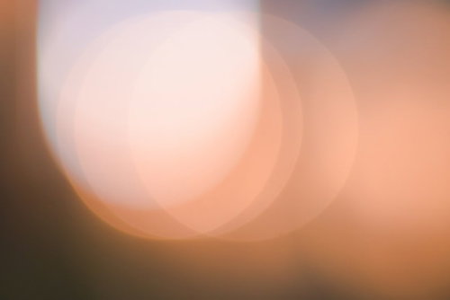 オレンジ色に重なりあう柔らかな光と暖色グラデーション